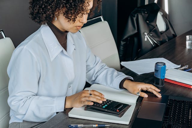 an accountant working at their desk and using a calculator