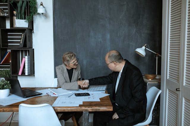 two people sitting at table looking over financial documents