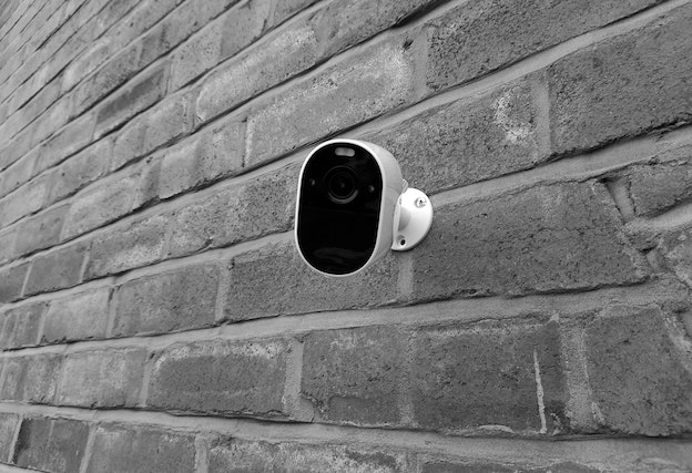 small security camera on a gray brick wall