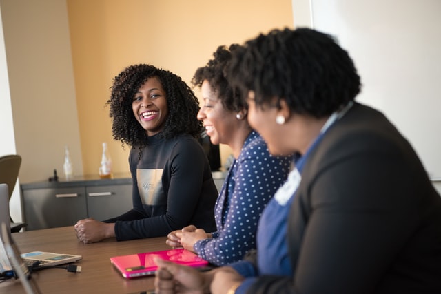 three people sitting at conference table