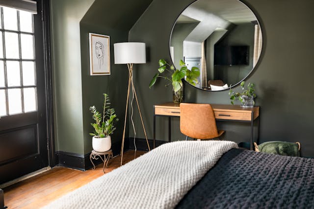 a deep green bedroom with a bunch of house plants