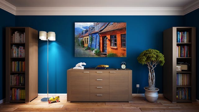 a dresser and two bookcases again a dark blue wall
